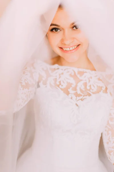 O sorriso alegre da bela noiva levantando o véu . — Fotografia de Stock