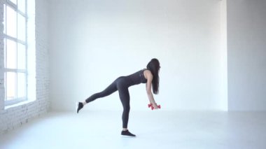 Tam uzunlukta yan görünüm dumbbells ile ağız kavgası yapıyor ve bacak kadar beyaz stüdyoda yükselterek genç sporcumuz. 4 k görüntüleri.