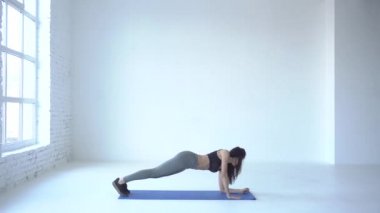 Kardiyo egzersizleri. Sportif eğitmen beyaz Studio tahta aşağı yukarı yaparak ısınmaya başladı. 4 k görüntüleri.