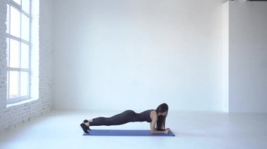 Tahta aşağı yukarı uygulanması genç atletik sporcumuz yoga mat beyaz Studio tarafından gerçekleştirilir. 4k.