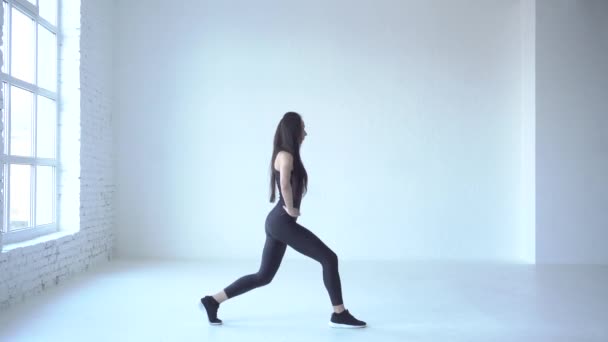 Side full-length view of the athletic sporstwoman doing the walking lunges in white isolated studio. 4k. — Stock Footage Side full-length view of the athletic sporstwoman doing the walking lunges in white isolated studio. 4k. Stock Video