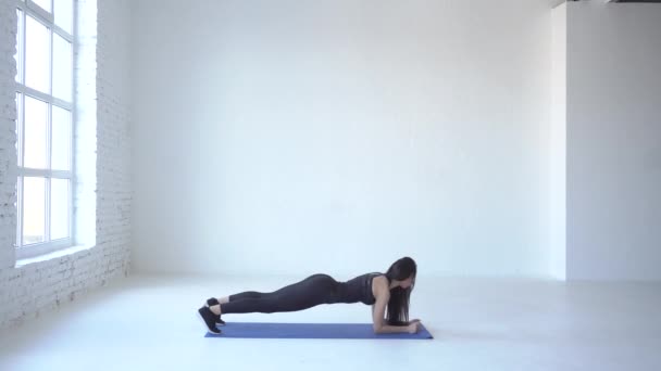 L'esercizio di up down plancia viene eseguito da giovane atleta sportiva sul tappetino yoga in studio bianco. 4k . — Video Stock