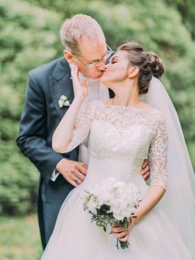 Çiçek açan bahçede öpüşme neşeli yeni evliler varoluş yaz fotoğrafı.