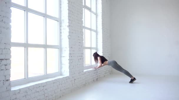 体操でフィットネス女性は、温暖化を窓枠に ups をやってします。スタジオの場所。4 k. — ストック動画