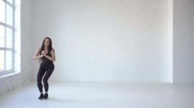 Yeni başlayanlar için dersler. Sportif sporcumuz beyaz Studio ayaklı ağız kavgası yaparak ısınmaya başladı. 4k.