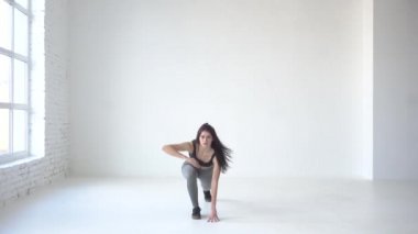 Tam uzunlukta görünümü lunges yapıyor ve el kadar yükselterek sıska sportif kadın. 4 k. beyaz stüdyo konumu.