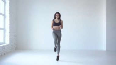 Sportif eğitmen ısınmaya başladı. O beyaz stüdyo bir yerde çalışıyor. 4k.