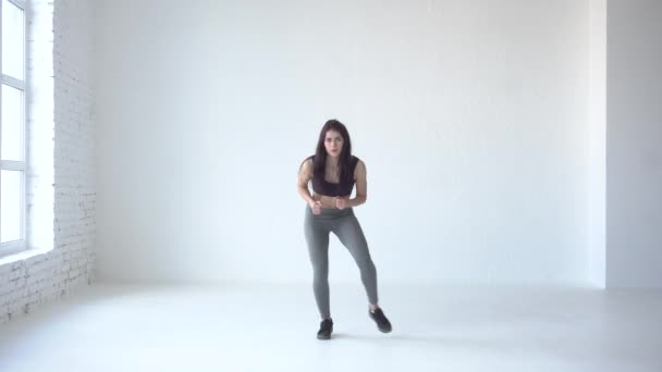 Exercices pour se réchauffer. Skinny sportive est en place en studio blanc. 4k . — Video