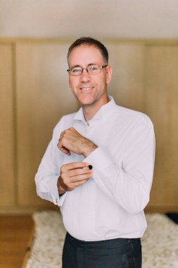 Kadar gömlek düğmelerini yakışıklı gülümseyen damat.