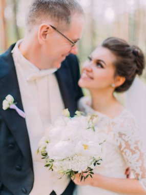 Mutlu yeni evliler elinde beyaz peonies harika düğün buket.