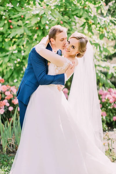 Damat sarılma ve öpüşme gülümseyen gelin. Park yeri.