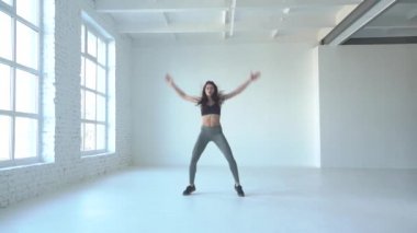 Spor kavram. Atlama yaparken sıska atletik kadın beyaz studio ağız kavgası.