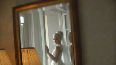 Yansıma şık gelinlik içinde çok güzel sarışın gelin aynaya peçe ve harika makyaj poz ile. Gelin s sabah.