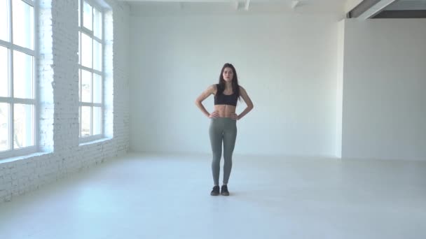 Sporty fitness trainer is performing lunges in white studio. — Stock Video