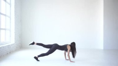 Sportif kadın bir kaldırdı ile elleri ve ayakları üzerinde yürüyerek ısınmaya başladı. Geri yürüyor. 4 k. Studio lcoation.