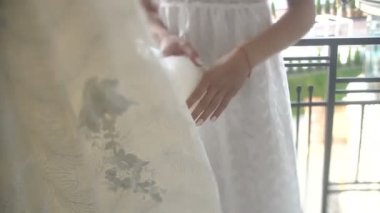 Güzel güzel sarışın gelin şık düğün elbisesini askıda asılı zevk alıyor.