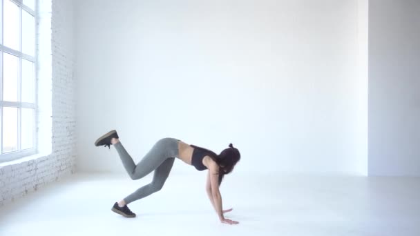 Femme sportive se réchauffe en marchant sur les mains et les jambes avec un levé. 4k. Enrobage de studio . — Video