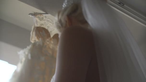 Portrait de la jeune mariée blonde attrayante avec un sourire charmant appréciant et touchant sa longue robe de mariée élégante . — Video