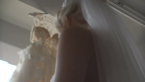 Ritratto della giovane sposa bionda attraente con sorriso affascinante godendo e toccare il suo lungo abito da sposa elegante . — Video Stock