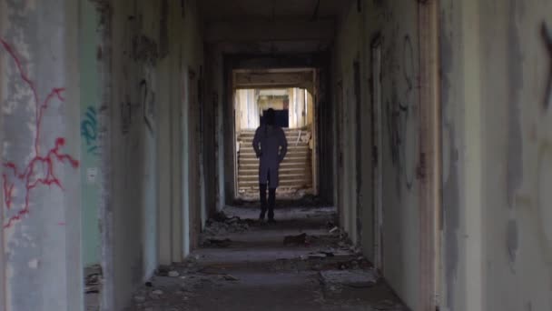 Le psychothérapeute africain marche le long des couloirs détruits de l'hôpital psychiatrique en ruine . — Video