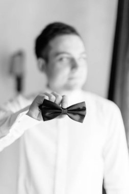 Yakın çekim görünümünü papyonlu damat elinde. Fotoğraf siyah renklerde.