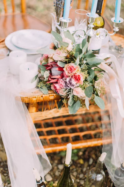 Vista de cerca del colorido ramo de rosas de la boda acostado en la mesa tejida . —  Fotos de Stock