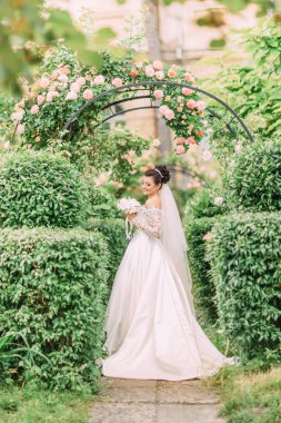 Bahçede düğün buket beyaz gül tutan güzel gülümseyen gelin.