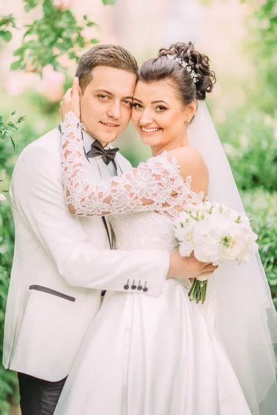 Düğün buketi tutan sarılma yeni evliler yan portresi.