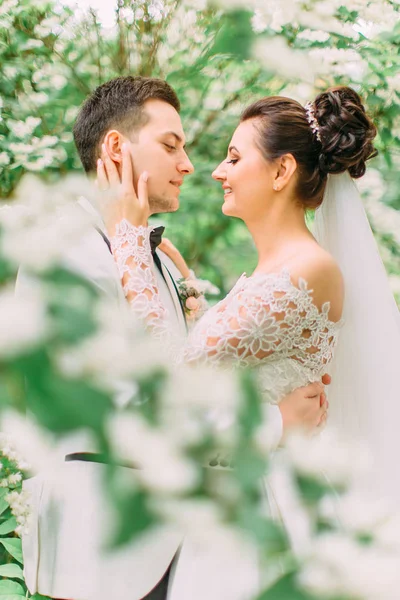 Gros plan portrait latéral de la mariée caressant le visage du marié souriant . — Photo