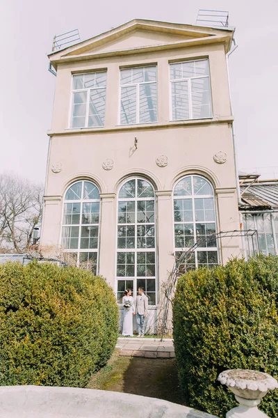 Sütunlar ve büyük vintage windows ile eski bej house yakınındaki şık genç çift. Paris'te Romantik düğün — Stok fotoğraf