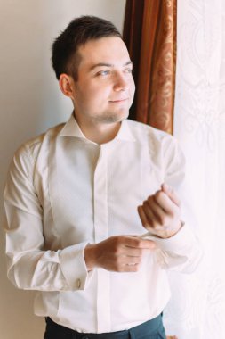 Damat pencereden bakarken gömlek kadar düğmelerini.