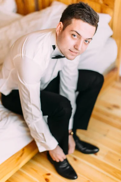 Close-up vista do belo noivo amarrando os sapatos de casamento . — Fotografia de Stock
