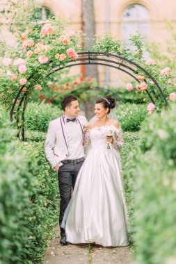 Yeşil bahçe yürüyüş mutlu yeni evliler tam uzunlukta görünümünü.