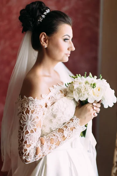 Ritratto laterale a mezza lunghezza della bella sposa che tiene il bouquet nuziale . — Foto Stock