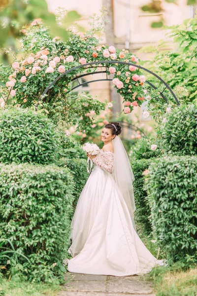 Vista completa de la novia sonriente con ramo de bodas en el jardín verde . —  Fotos de Stock