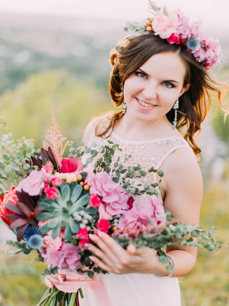 La vista de cerca de la novia sonriente sosteniendo el enorme ramo de bodas . —  Fotos de Stock