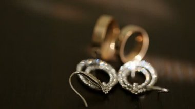 Altın alyans ve gümüş gelin küpe diamons masada ile yakın çekim görünümü.