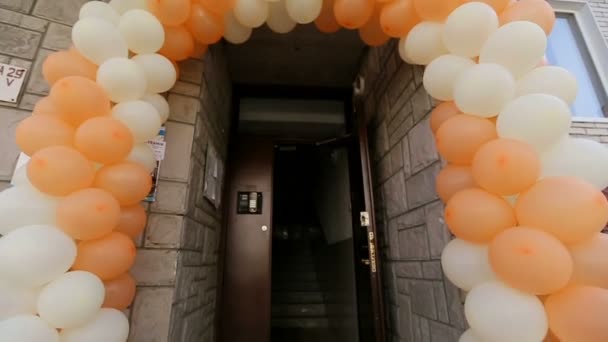 結婚式のドアを飾る白とオレンジ色の風船のアーチ。ない人. — ストック動画