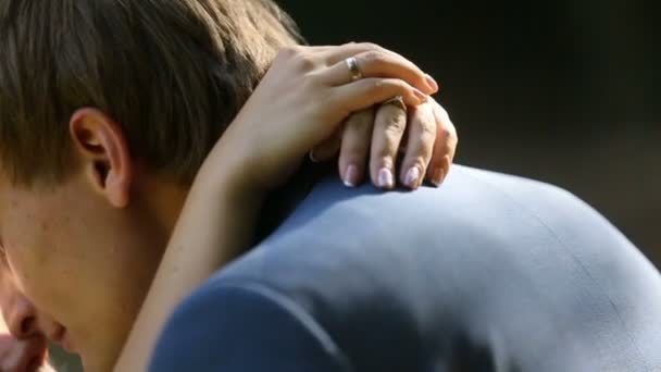 Portret van de jonge aantrekkelijke paar jonggehuwden teder knuffelen en zoenen in de zonovergoten. — Stockvideo