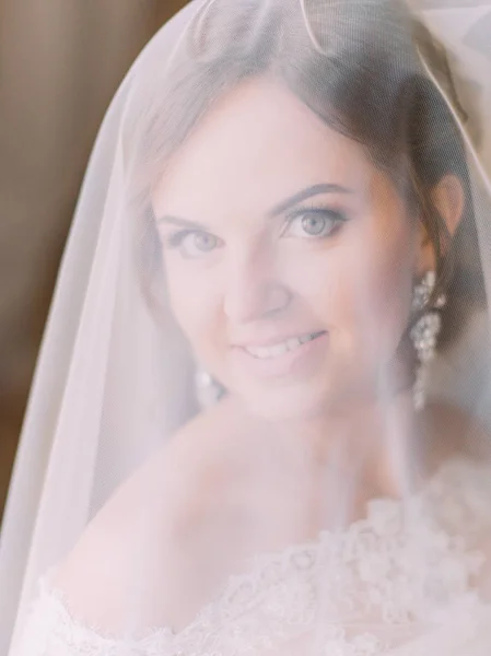 Närbild porträtt av leende bruden under slöjan. — Stockfoto