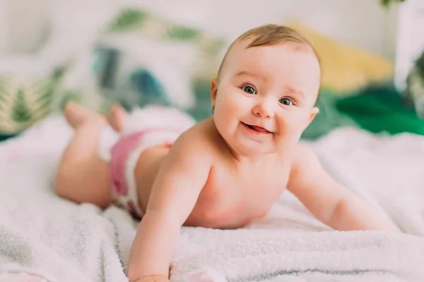 Le portrait en gros plan du torchon nu souriant couché sur le plaid blanc . — Photo