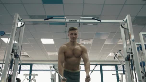 Handsome muscular sportsman with naked torso warming out on the fitness station. He is training his triceps. 4k footage. — Stock Video