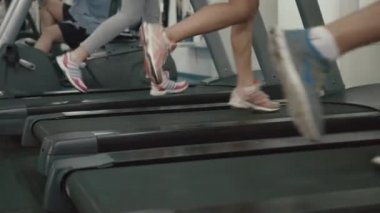 Modern spor salonunda treadmill egzersiz spor giyim bilinmeyen sportif sıska insanlar. 4 k görüntüleri.