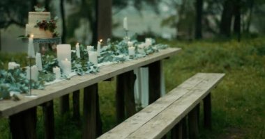 Romantik bir atmosfer. Tablo iki kişilik servis. Yapraklar, çiçekler, iki katmanlı kek çilek ve mumları masanın kapsayan vardır. 4 k görüntüleri.