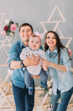 Gülümseyen veliler sallanan ve onların bebek ile güzel bir şekilde dekore edilmiş evde oynarken.