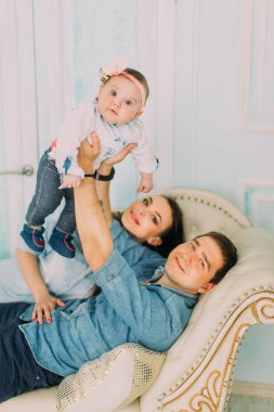 Kanepede yatan mutlu aile güzel dikey portresi. Babası küçük bebek yetiştirme.