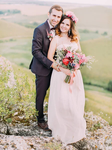 Усміхнений наречений затягує веселу наречену назад у гори . — стокове фото