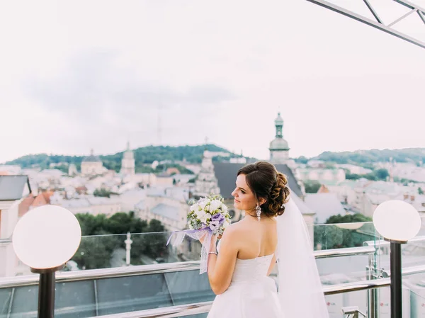 Die horizontale Ansicht der Braut beim Blick auf die Stadt. — Stockfoto