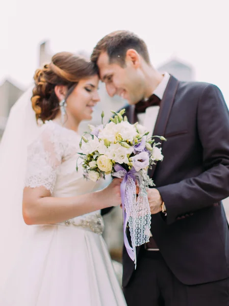 Il bouquet da sposa di rose bianche sullo sfondo sfocato degli sposi novelli . — Foto Stock