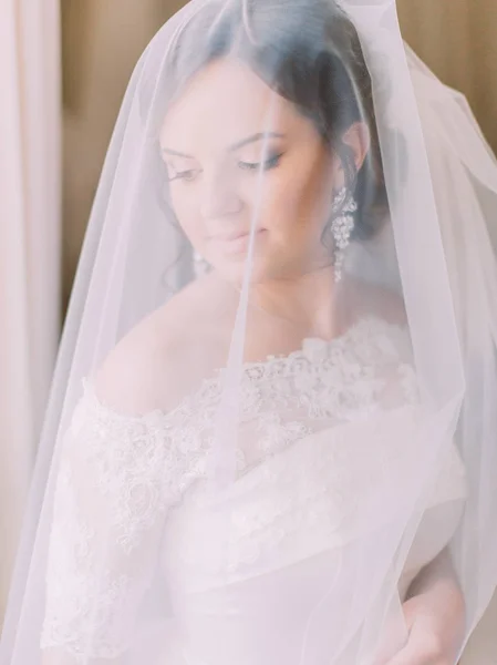 Det vertikala porträttet av bruden tittar åt sidan under slöjan. — Stockfoto